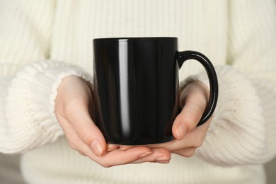 Photo of Woman with black ceramic cup, closeup. Mockup for design