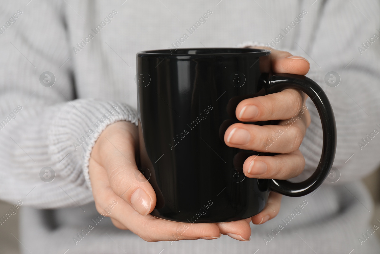 Photo of Woman with black ceramic cup, closeup. Mockup for design