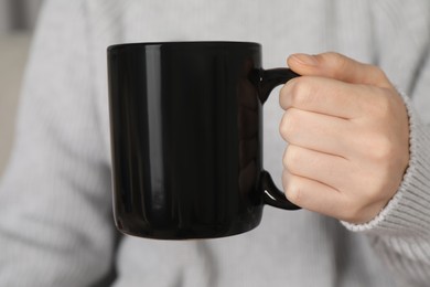 Photo of Woman with black ceramic cup, closeup. Mockup for design