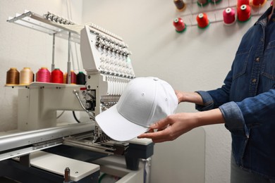 Photo of Woman with blank baseball cap for print indoors, closeup