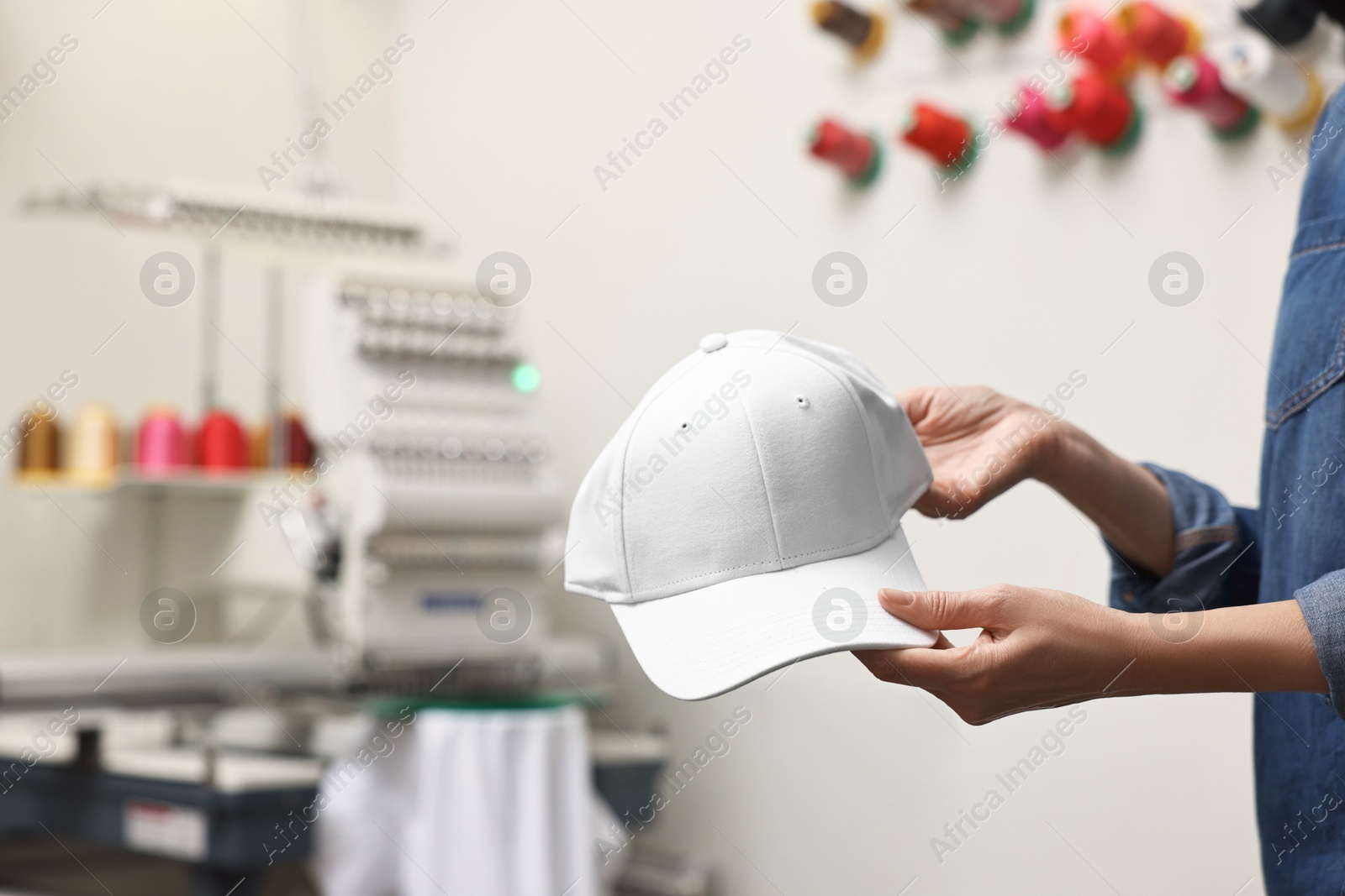 Photo of Woman with blank baseball cap for print indoors, closeup