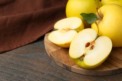 Photo of Fresh ripe yellow apples on wooden table, closeup. Space for text