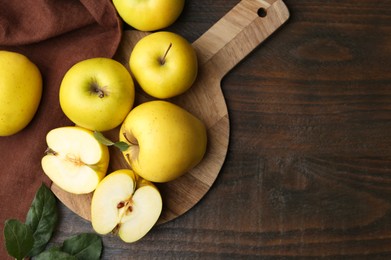 Photo of Fresh ripe yellow apples and leaves on wooden table, flat lay. Space for text