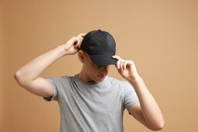 Man in stylish baseball cap on beige background. Mockup for design