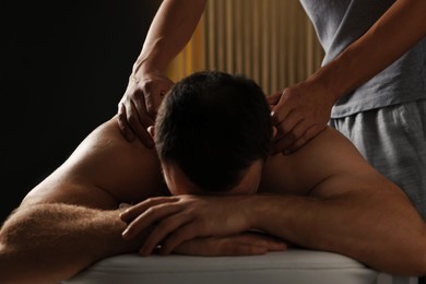 Photo of Professional physiotherapist doing neck massage for his client indoors, closeup