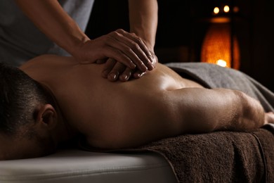 Professional physiotherapist doing shoulder massage for his client indoors, closeup