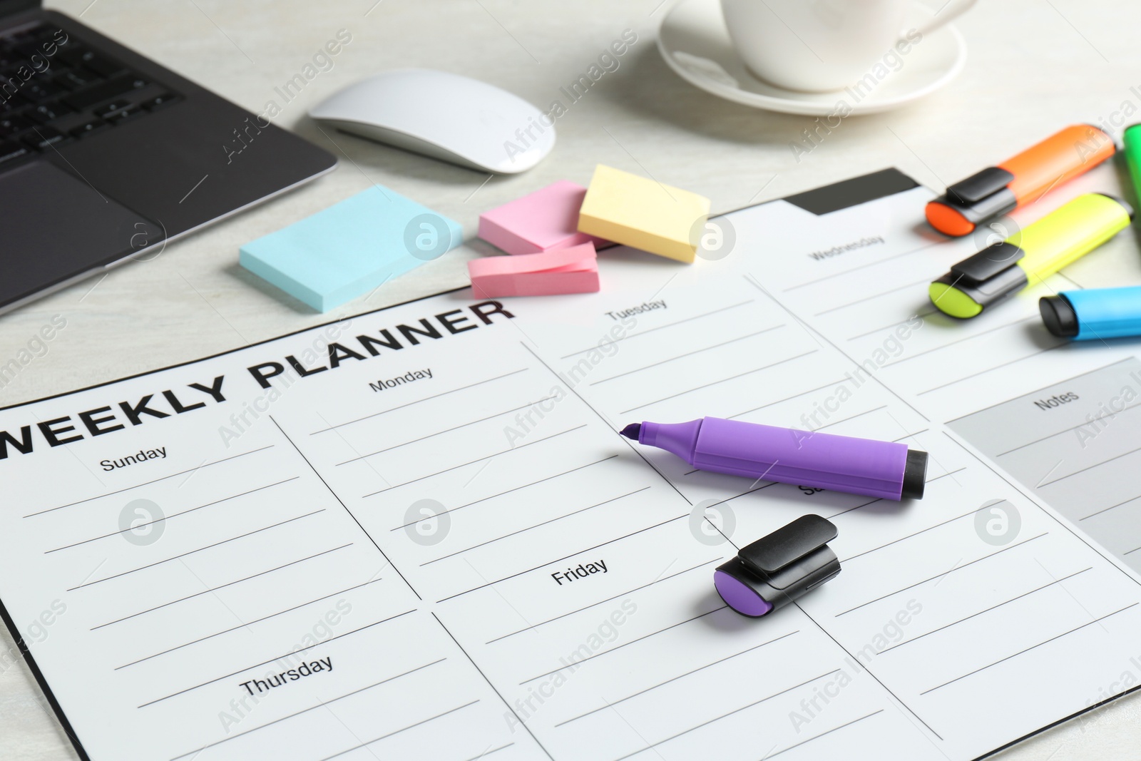 Photo of Timetable. Weekly planner, stationery and laptop on white table, closeup