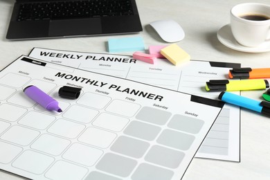 Timetable. Different planners, stationery, laptop and coffee on white table, closeup