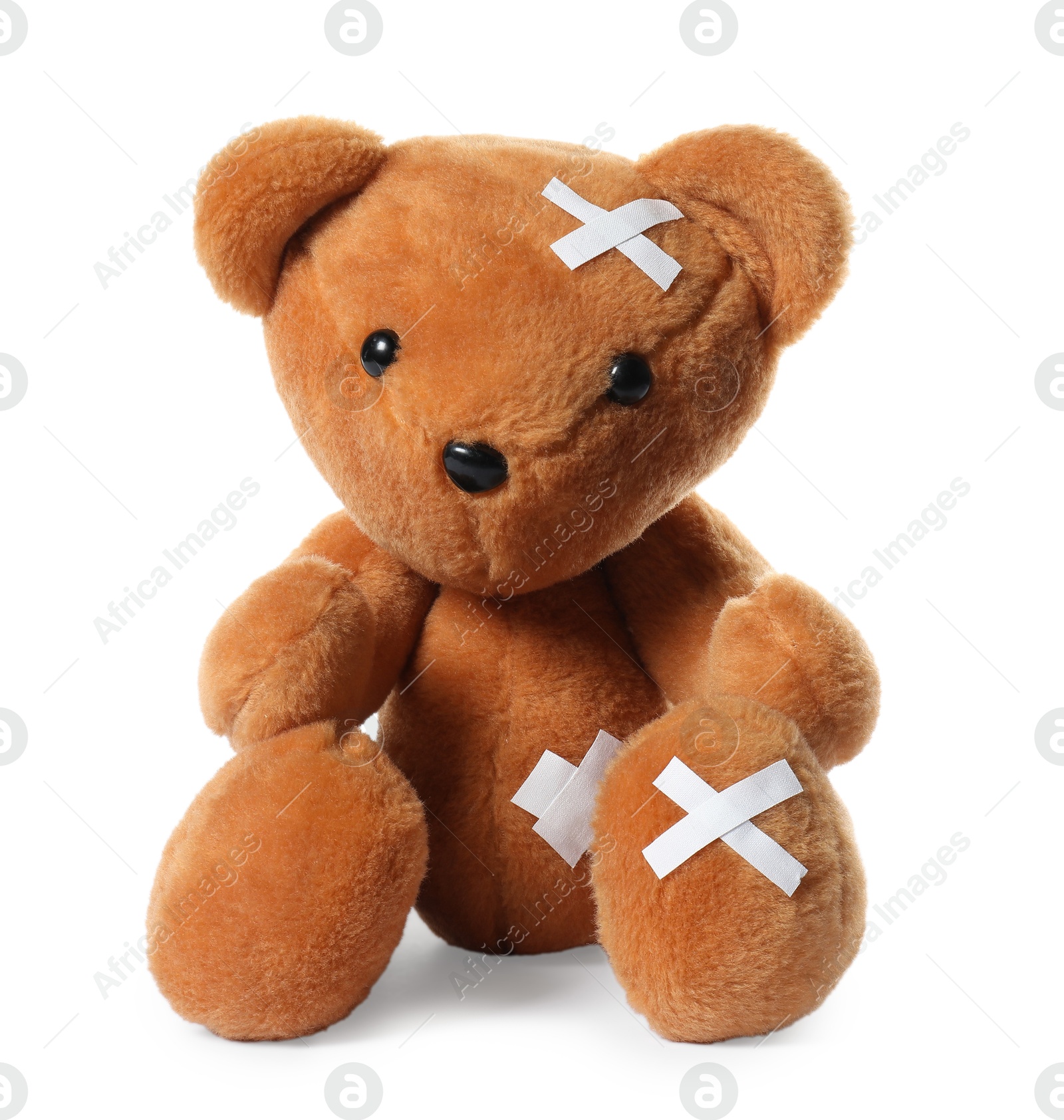 Photo of Teddy bear with adhesive medical bandages isolated on white