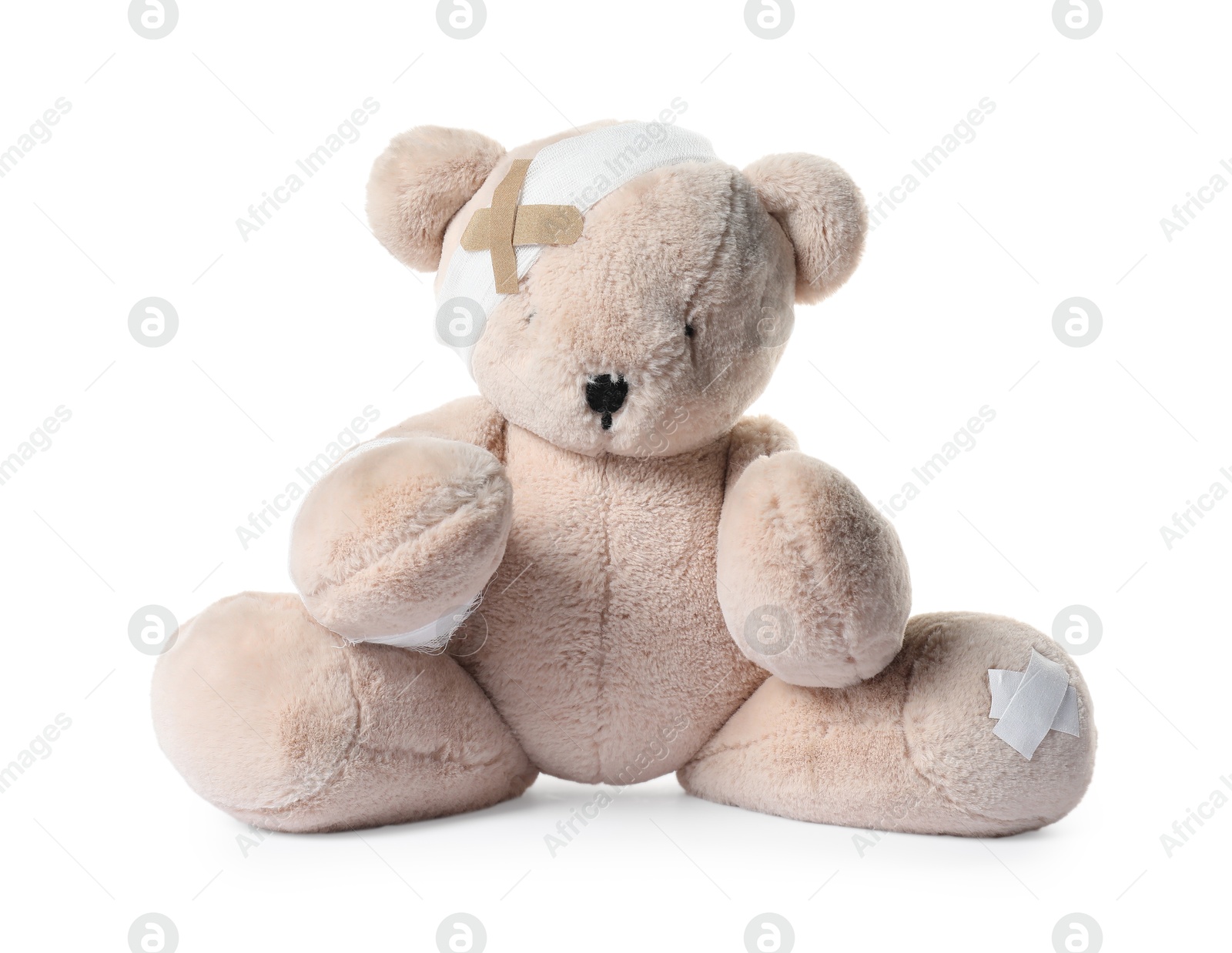 Photo of Teddy bear with bandages and adhesive medical plasters isolated on white