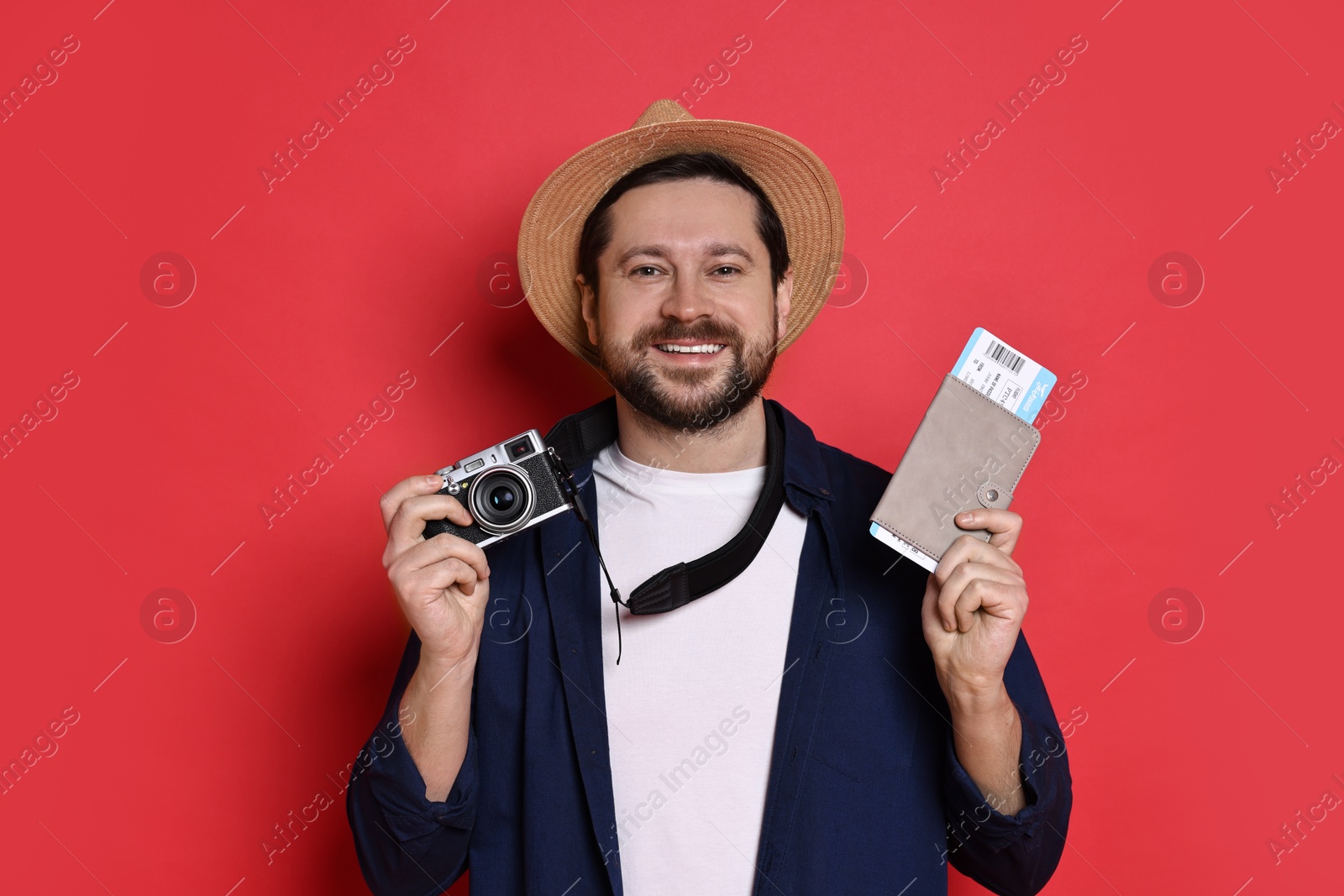 Photo of Traveller with vintage camera, passport and ticket on red background