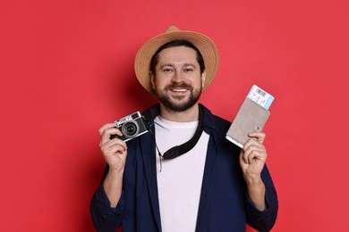 Photo of Traveller with vintage camera, passport and ticket on red background