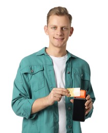 Happy young man with payment terminal and debit card on white background