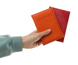 Photo of Woman holding passports in bright covers on white background, closeup