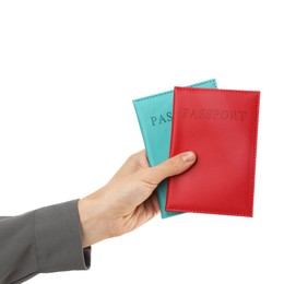 Photo of Woman holding passports in bright covers on white background, closeup