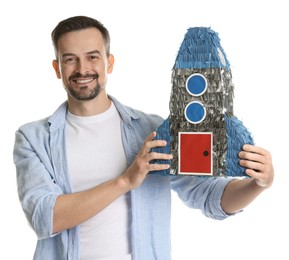 Happy man with rocket shaped pinata on white background