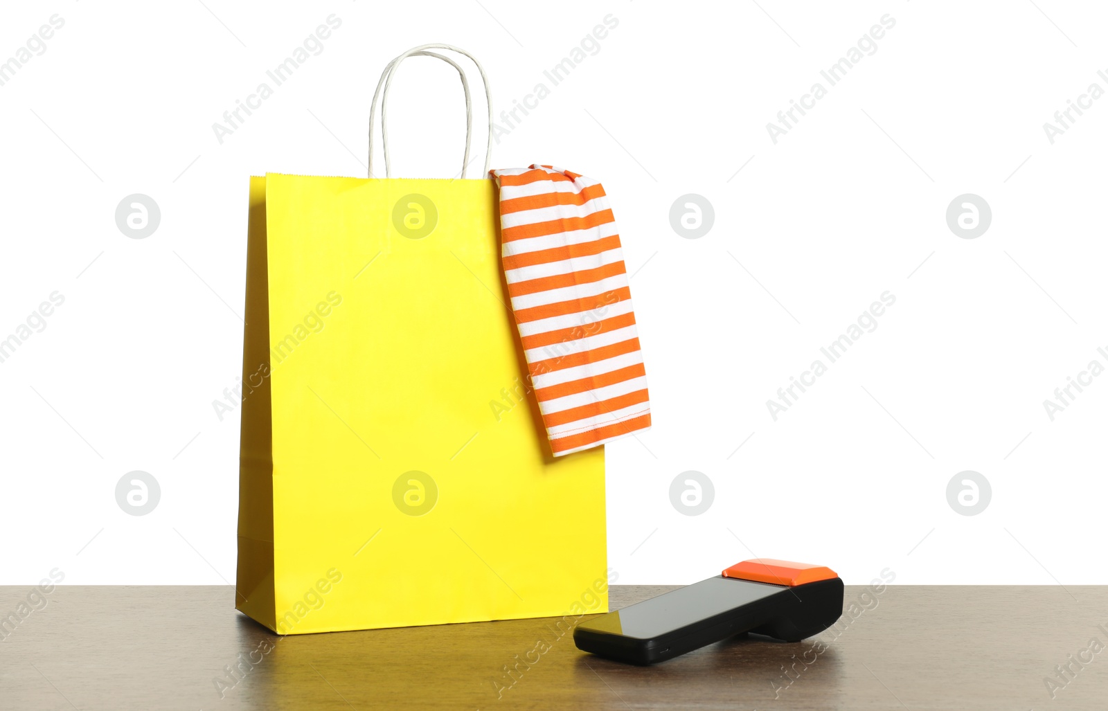 Photo of Payment terminal, shopping bag, high heeled shoes and cloth on wooden table against white background