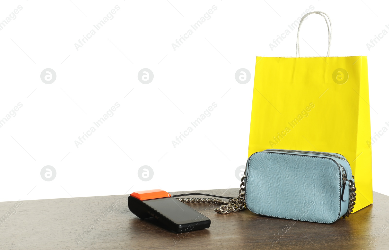 Photo of Payment terminal, purse and shopping bag on wooden table against white background