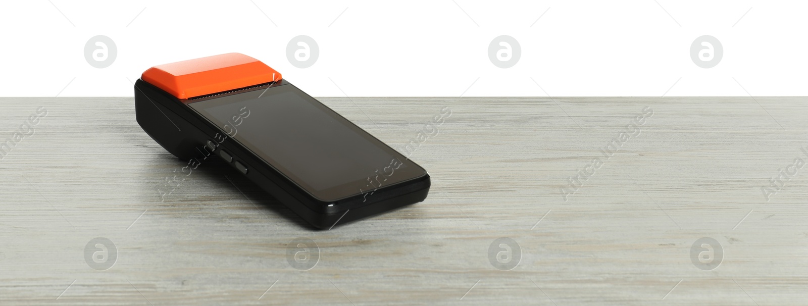 Photo of Payment terminal on wooden table against white background