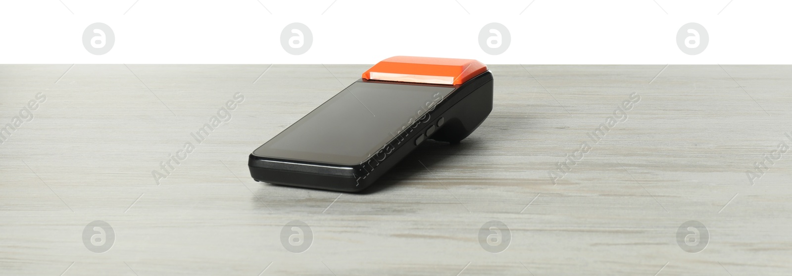 Photo of Payment terminal on wooden table against white background