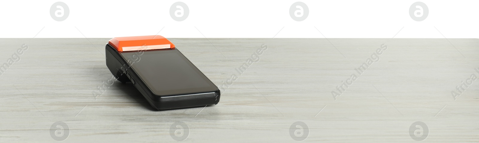 Photo of Payment terminal on wooden table against white background