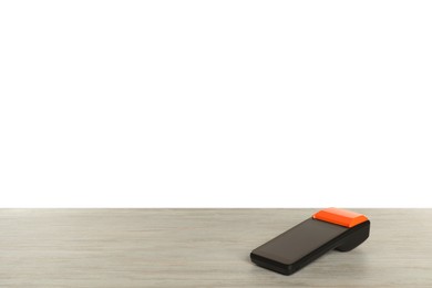 Photo of Payment terminal on wooden table against white background