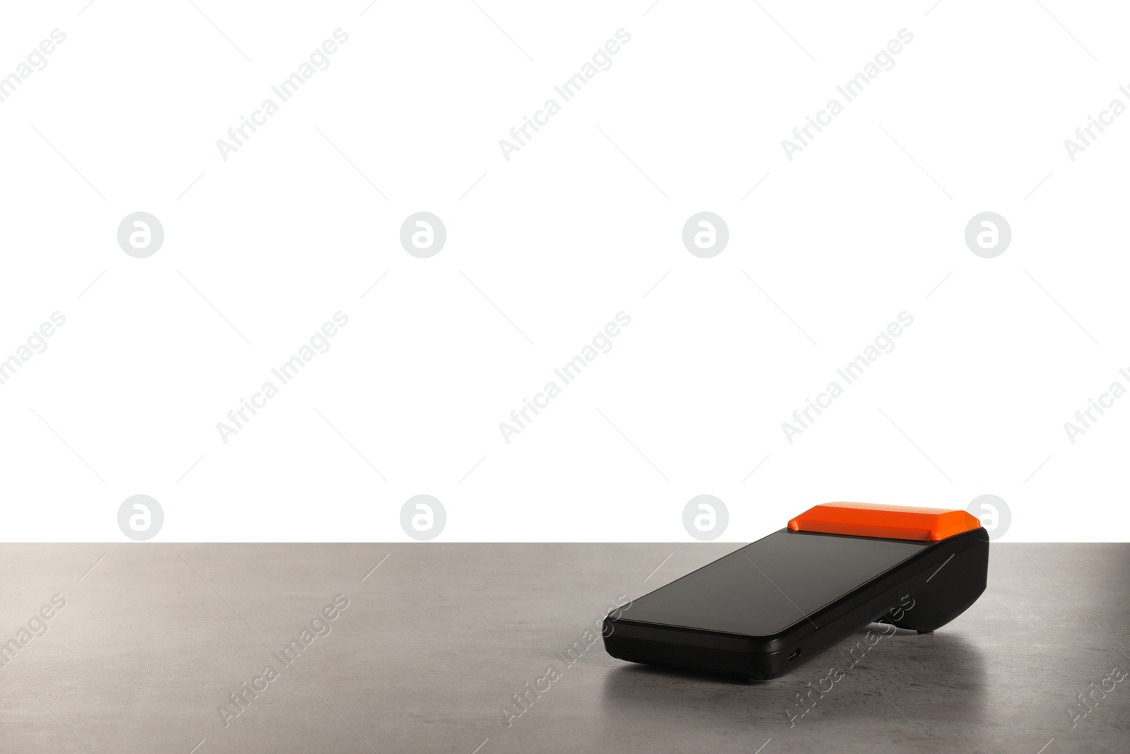 Photo of Payment terminal on grey table against white background