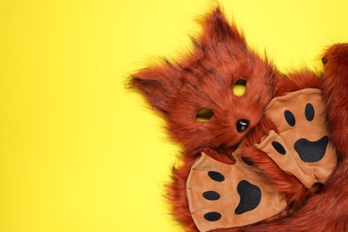 Photo of Quadrobics. Fox mask, tail and gloves on yellow background, top view. Space for text