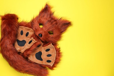 Photo of Quadrobics. Fox mask, tail and gloves on yellow background, top view. Space for text