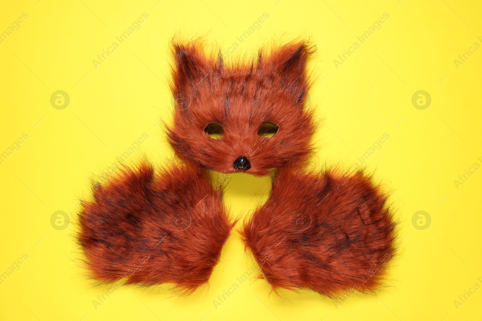 Photo of Quadrobics. Fox mask and gloves on yellow background, top view