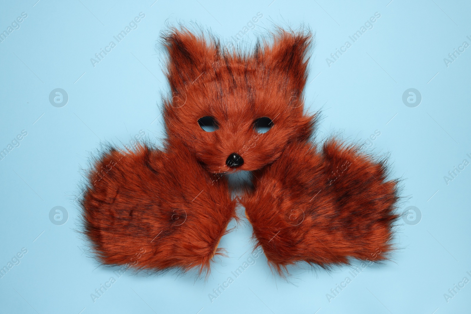 Photo of Quadrobics. Fox mask and gloves on light blue background, top view