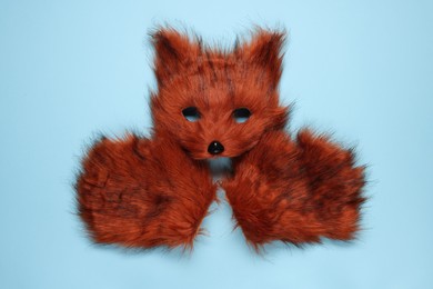 Photo of Quadrobics. Fox mask and gloves on light blue background, top view