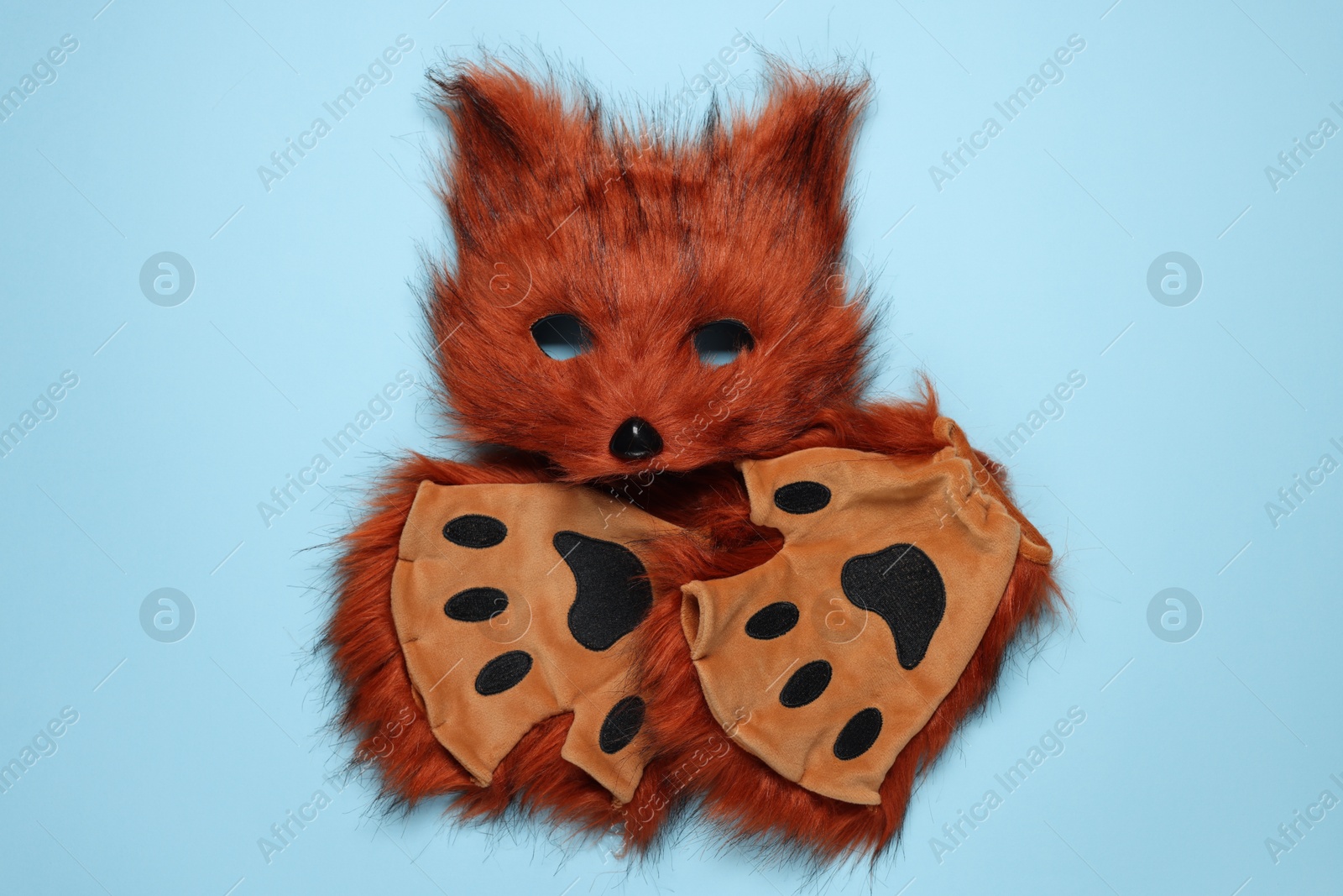 Photo of Quadrobics. Fox mask and gloves on light blue background, top view