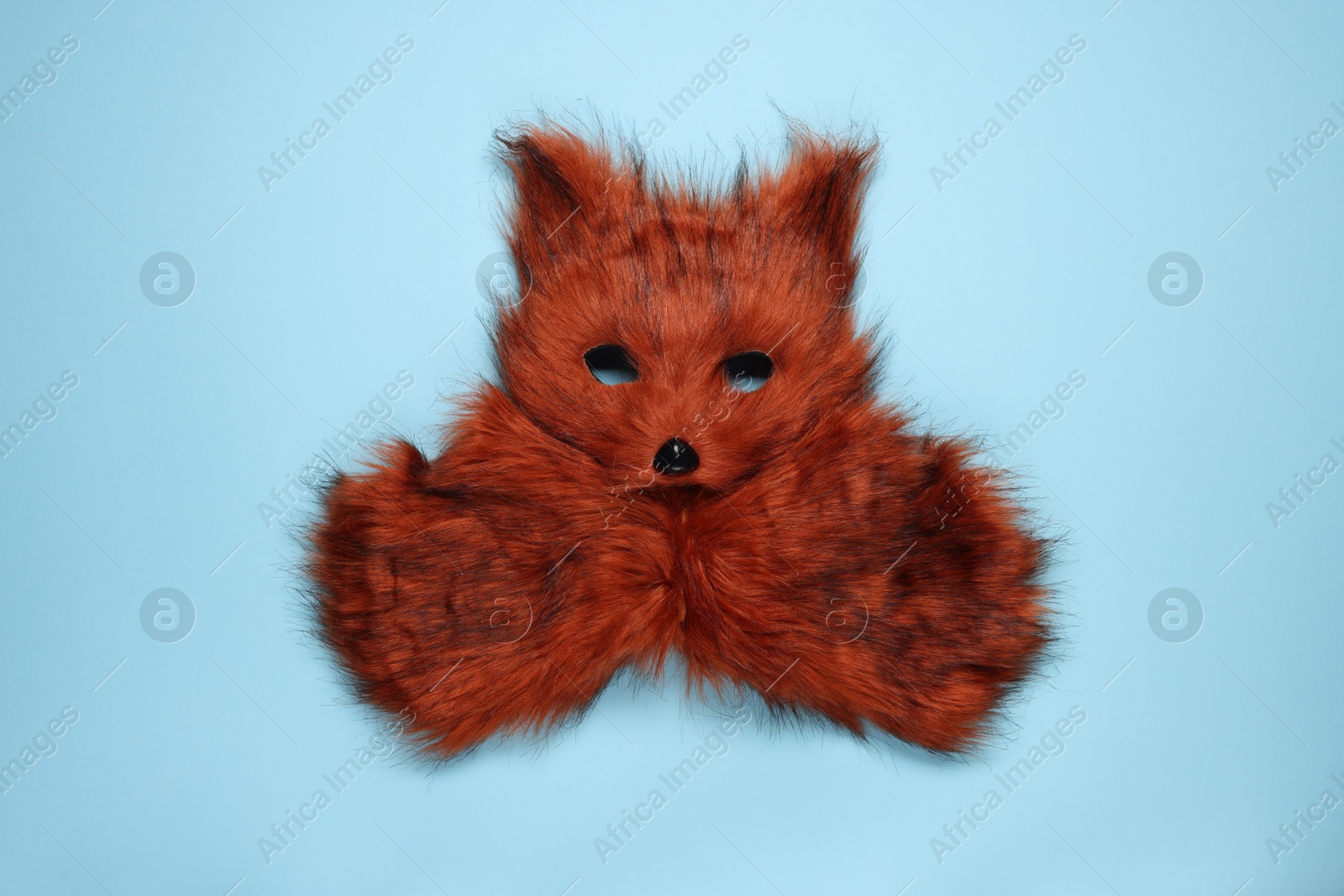 Photo of Quadrobics. Fox mask and gloves on light blue background, top view