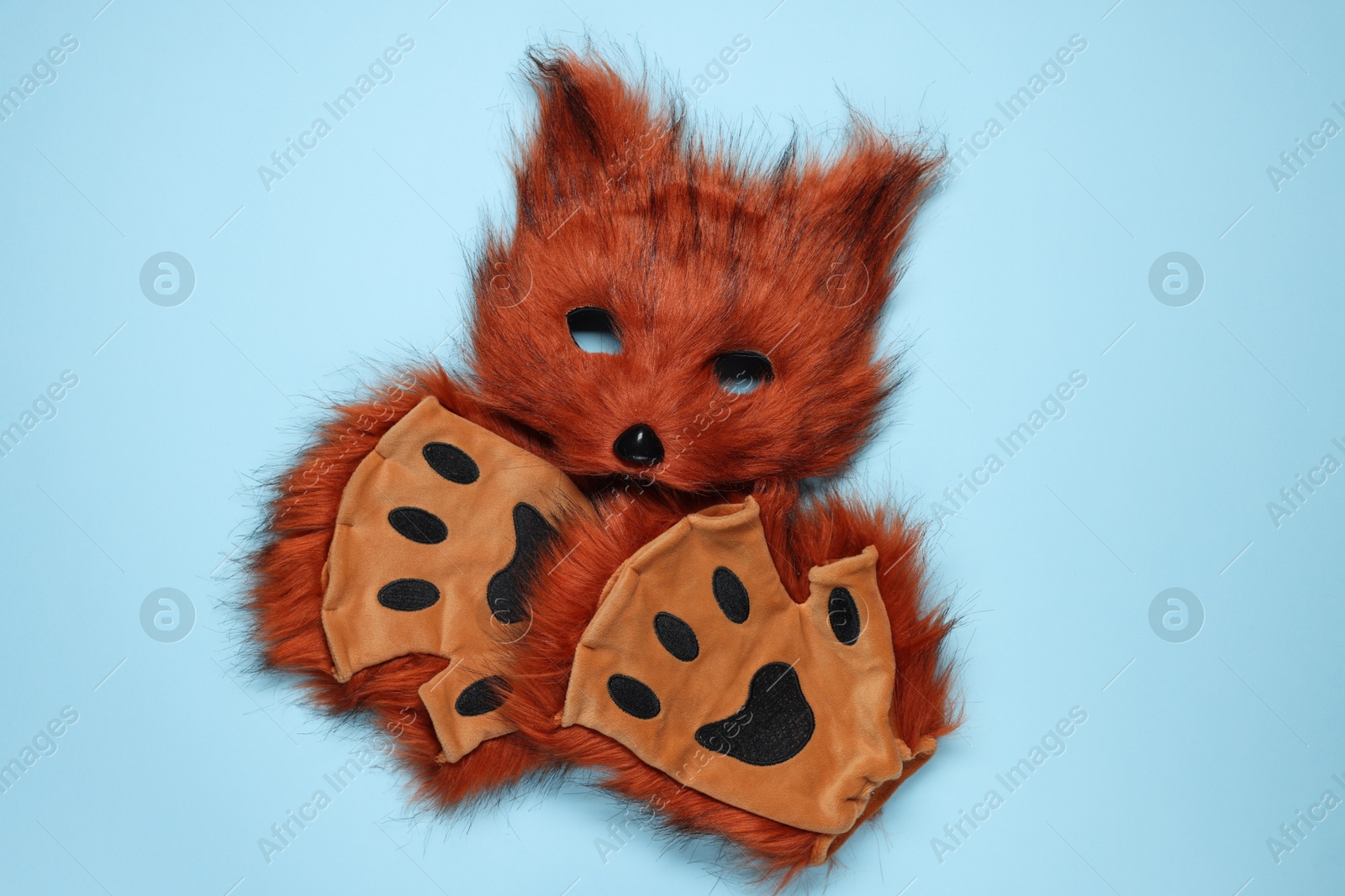 Photo of Quadrobics. Fox mask and gloves on light blue background, top view