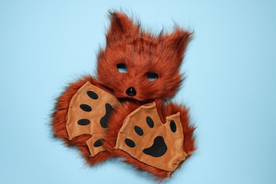 Photo of Quadrobics. Fox mask and gloves on light blue background, top view