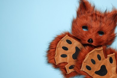 Quadrobics. Fox mask and gloves on light blue background, top view. Space for text