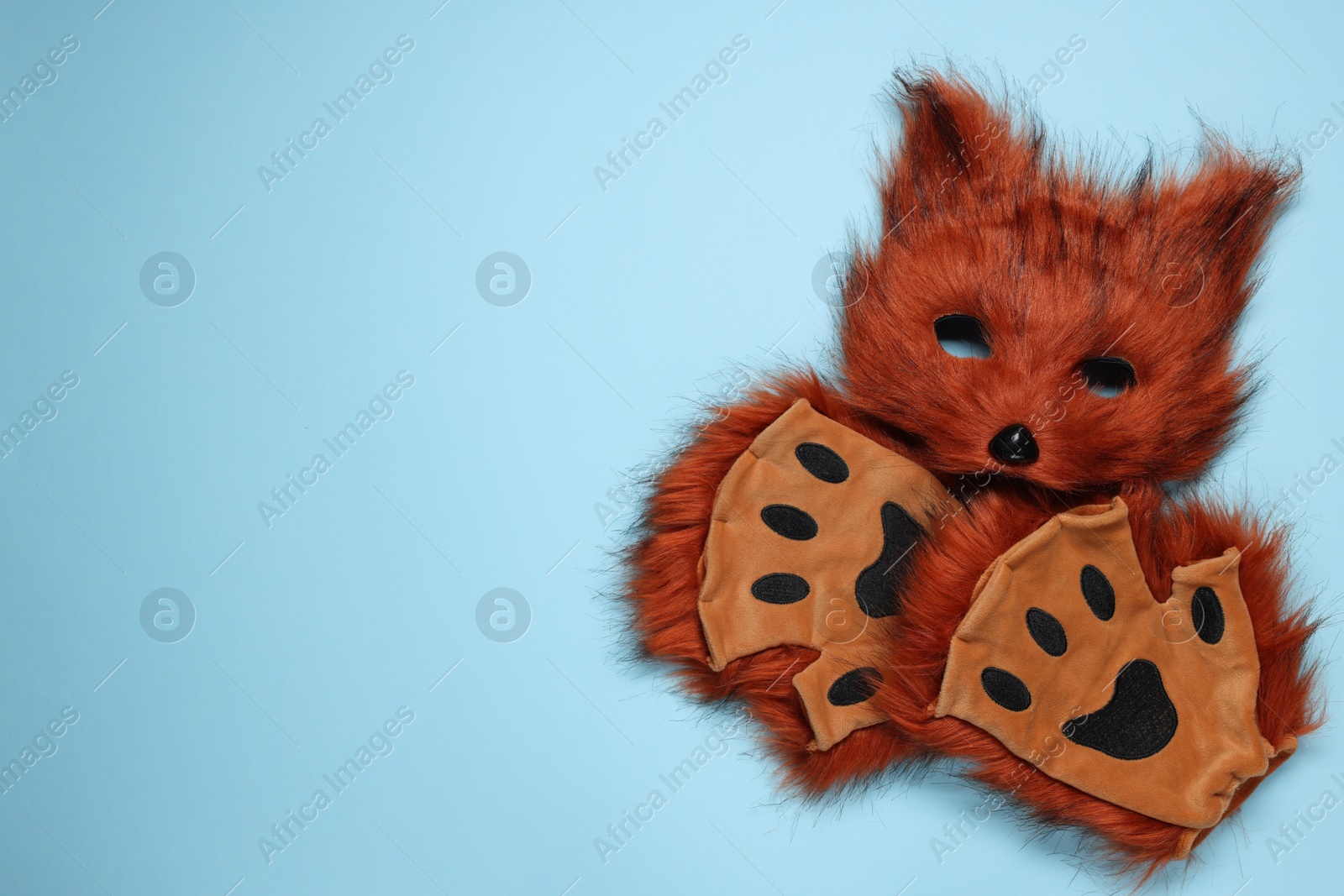 Photo of Quadrobics. Fox mask and gloves on light blue background, top view. Space for text