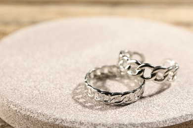 Photo of Stylish silver rings on pink textured surface, closeup. Space for text