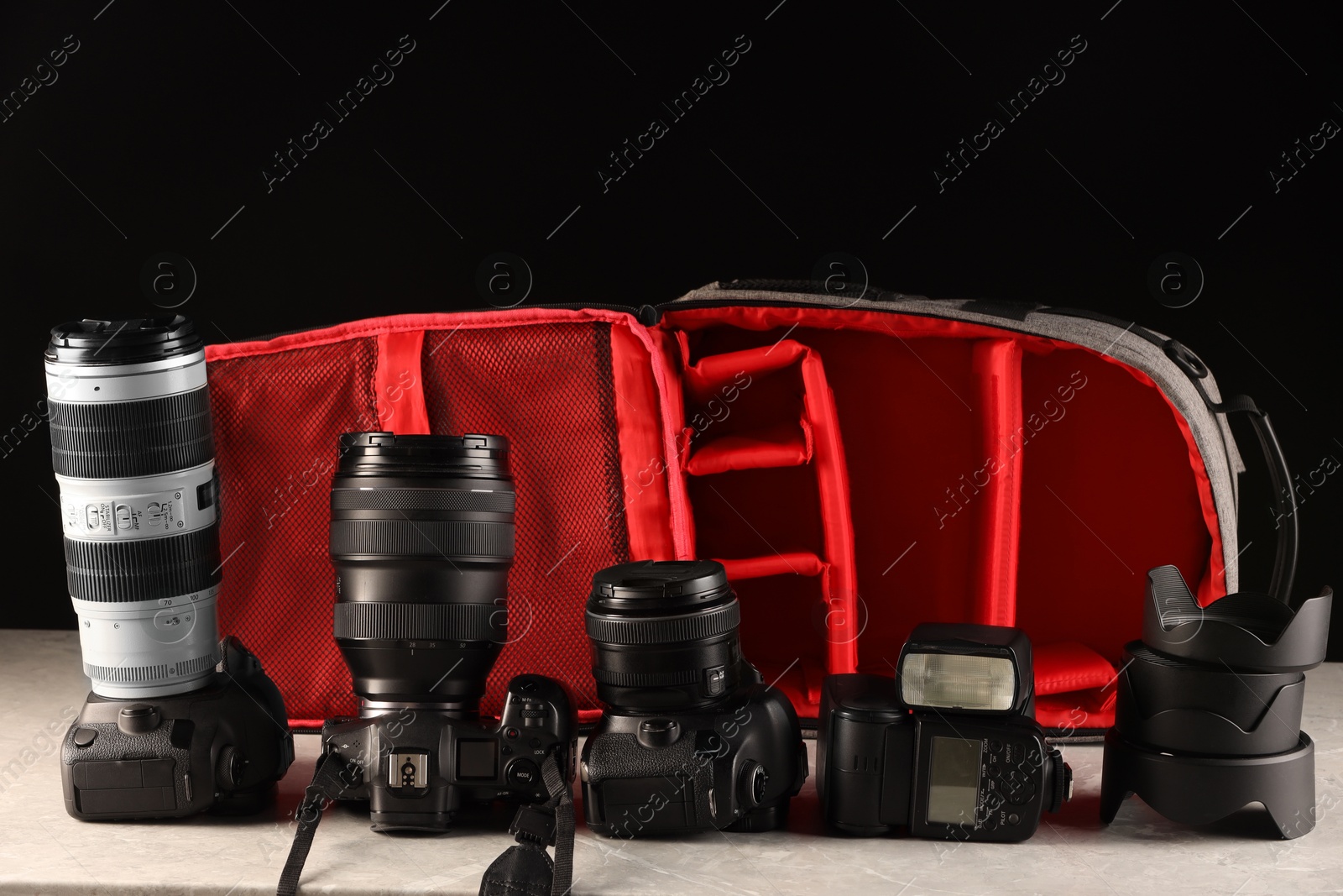 Photo of Professional photographer's equipment and backpack on light table