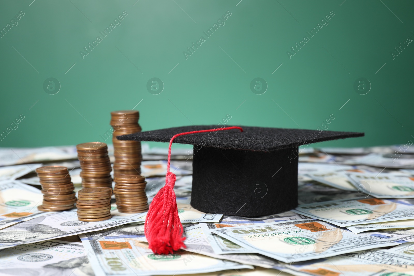 Photo of Graduate hat and coins on dollar banknotes, closeup. Tuition payment