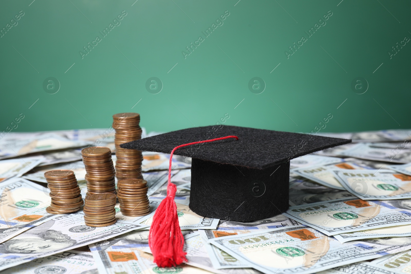 Photo of Graduate hat and coins on dollar banknotes, closeup. Tuition payment