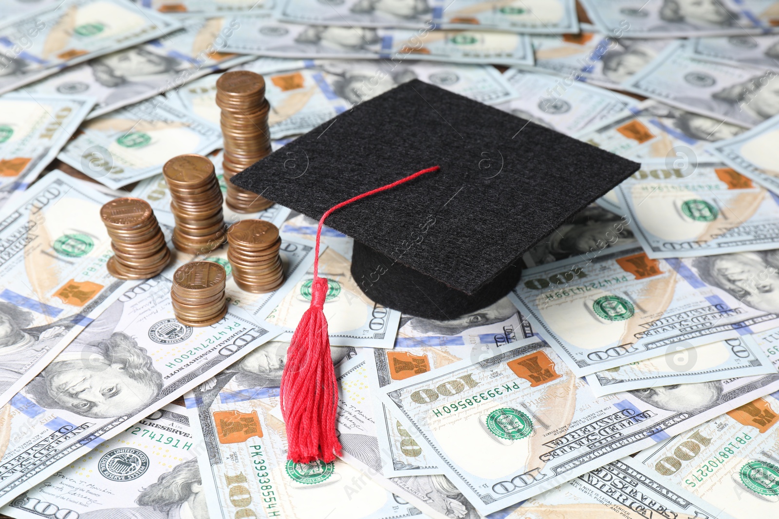 Photo of Graduate hat and coins on dollar banknotes, closeup. Tuition payment