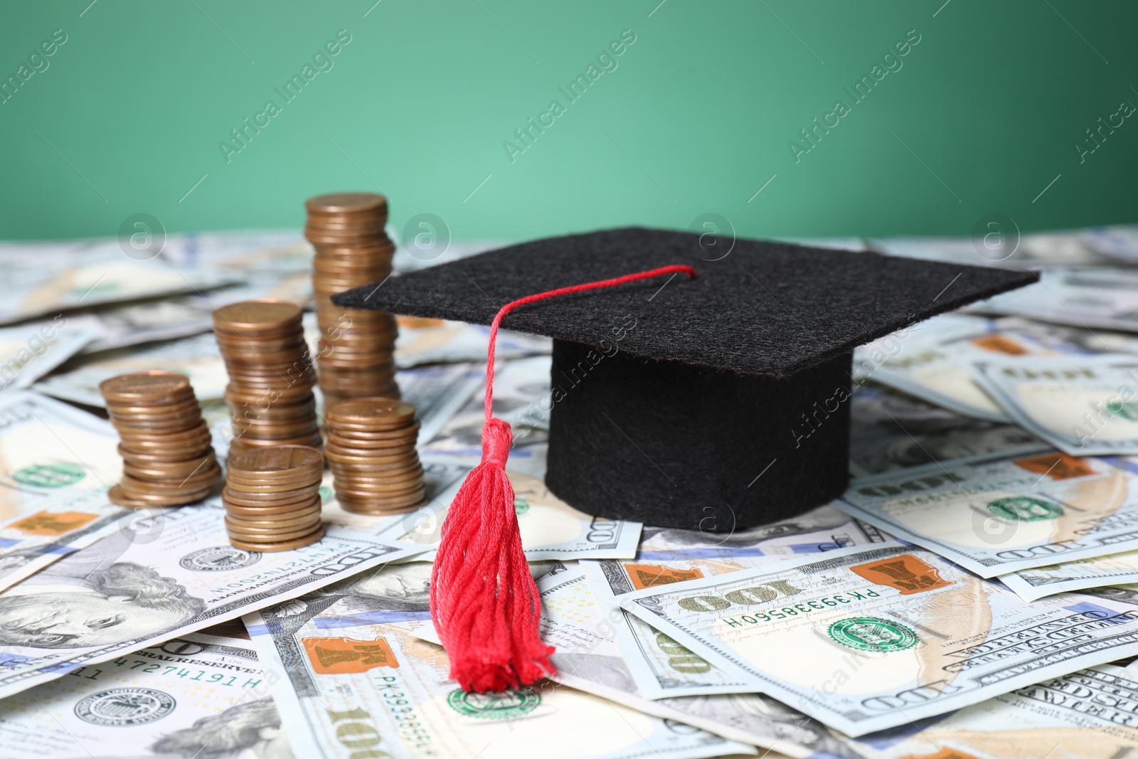 Photo of Graduate hat and coins on dollar banknotes, closeup. Tuition payment