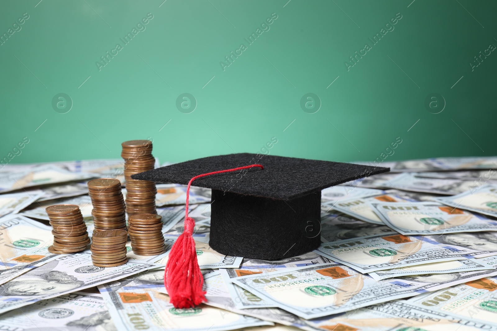 Photo of Graduate hat and coins on dollar banknotes, closeup. Tuition payment