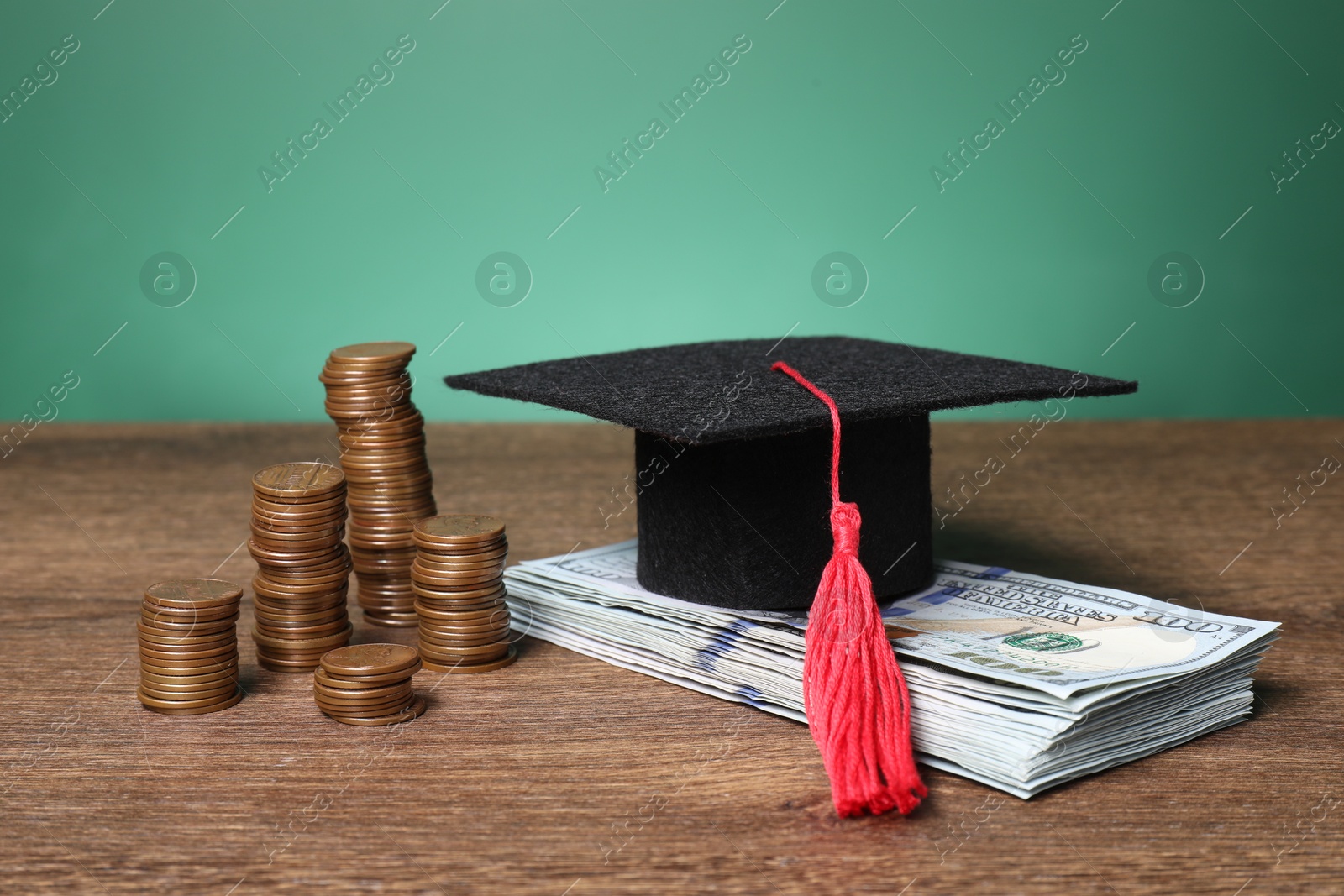 Photo of Graduate hat, dollar banknotes and coins on wooden table, closeup. Tuition payment