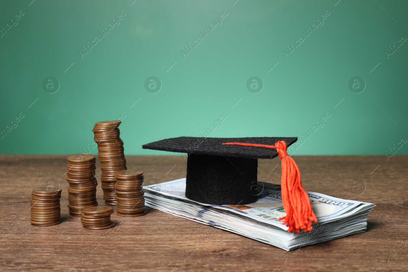 Photo of Graduate hat, dollar banknotes and coins on wooden table, closeup. Tuition payment