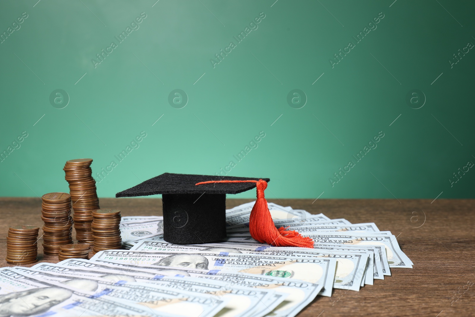 Photo of Graduate hat, dollar banknotes and coins on wooden table. Tuition payment