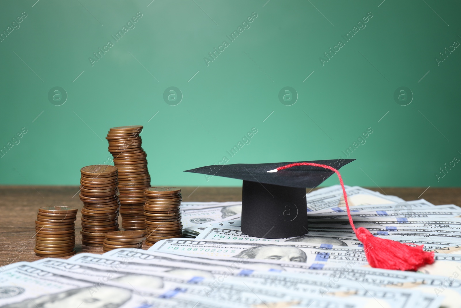 Photo of Graduate hat, dollar banknotes and coins on wooden table, closeup. Tuition payment