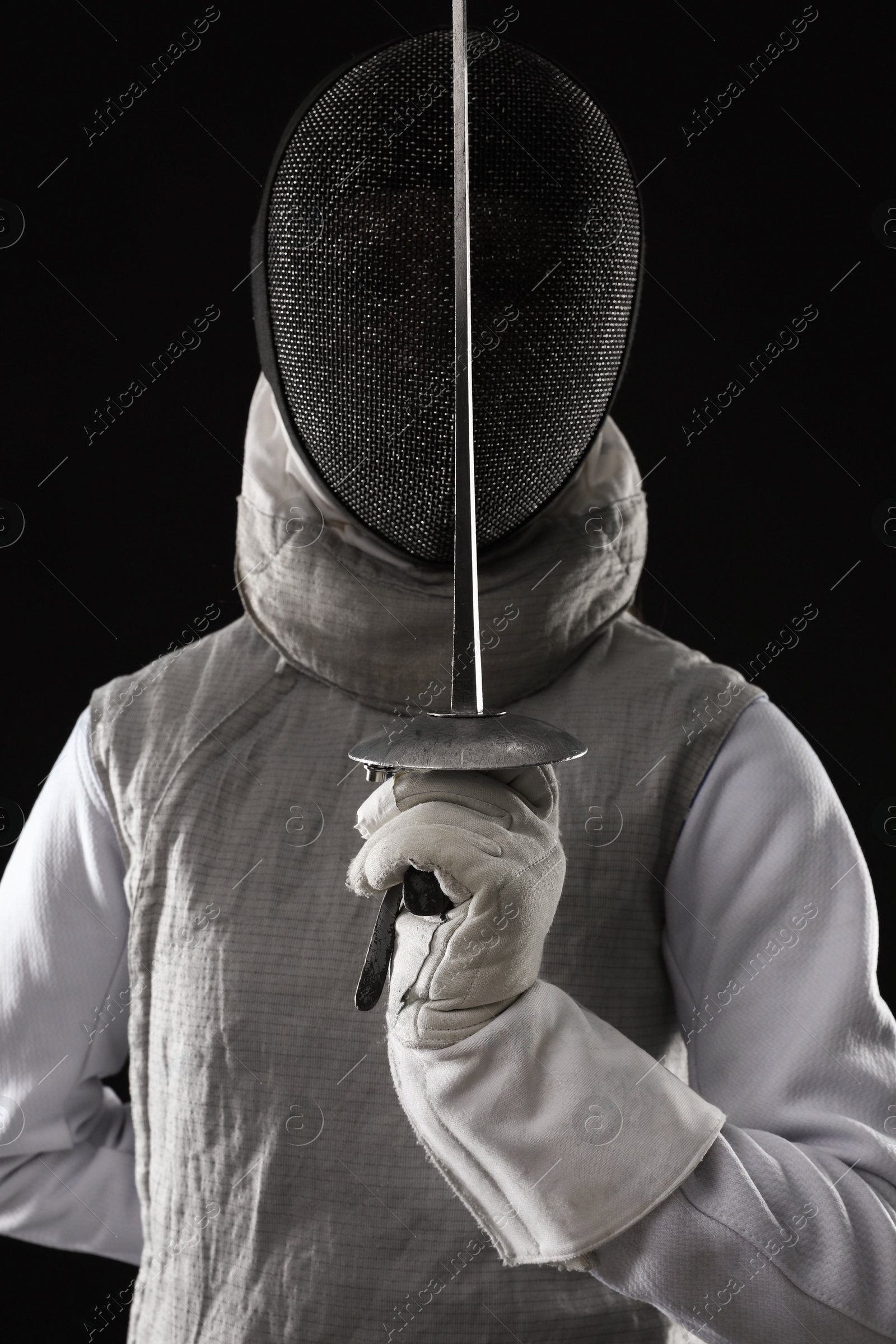 Photo of Fencer with epee on black background. Combat sport